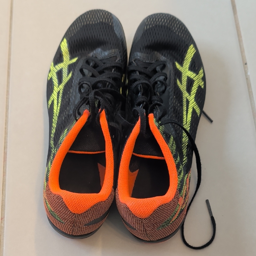 Asics Resurgence XC spikes in a black and safety yellow colorway. 